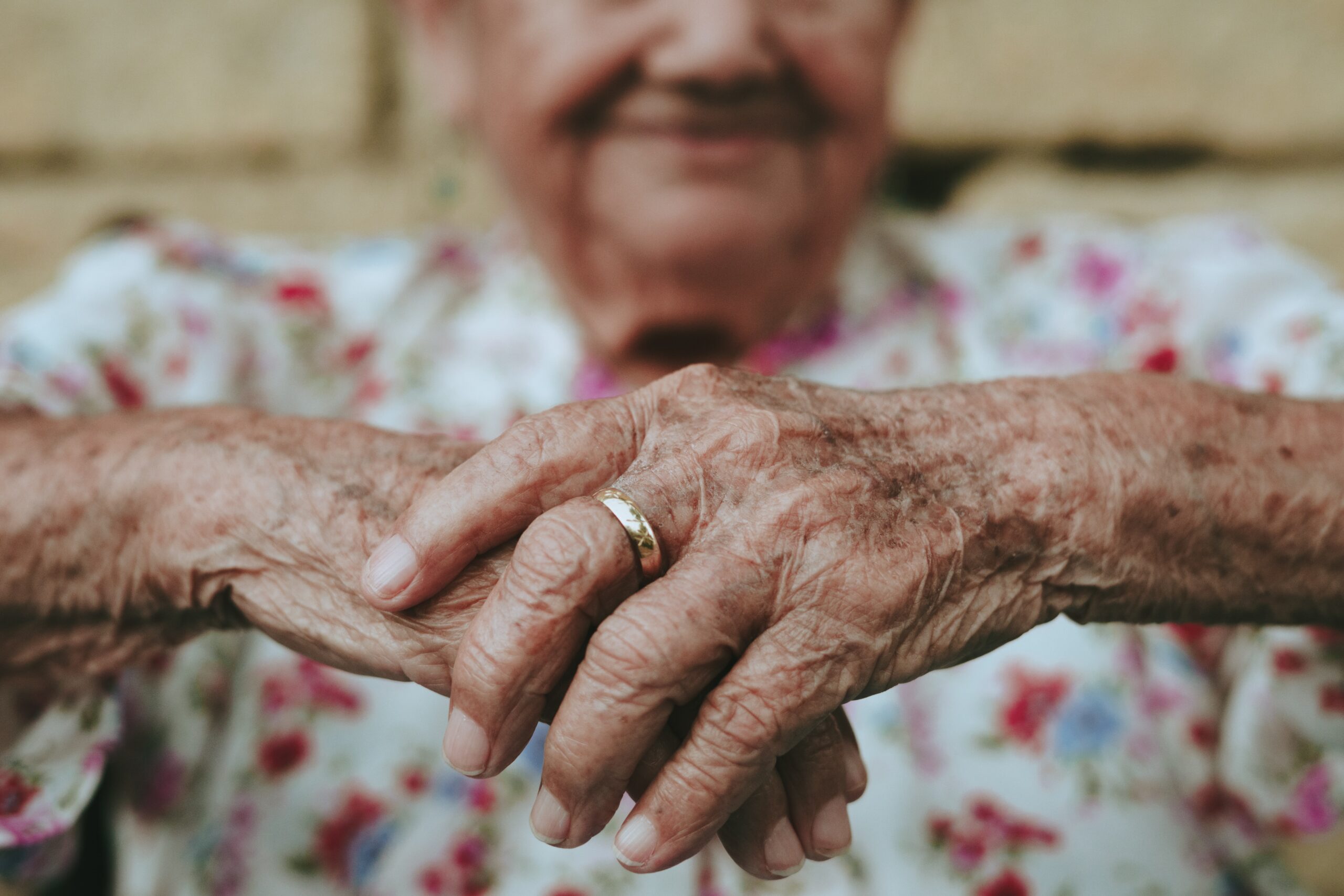 Elderly person's hands and arms for article on scams targeting seniors.